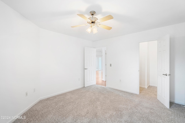 carpeted spare room with ceiling fan