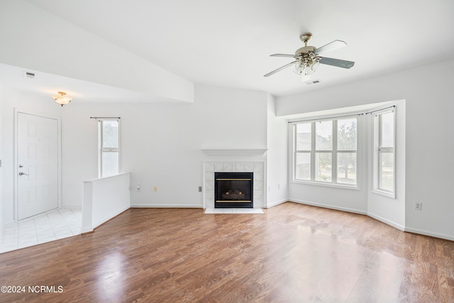 unfurnished living room featuring a fireplace, light hardwood / wood-style floors, and a wealth of natural light