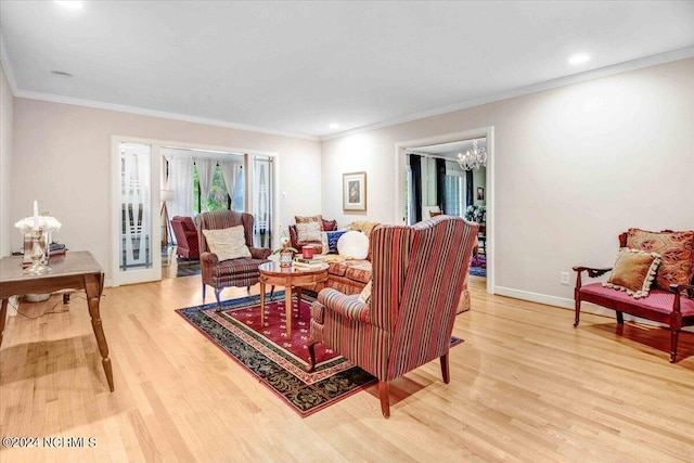 living room with ornamental molding, a chandelier, and hardwood / wood-style flooring