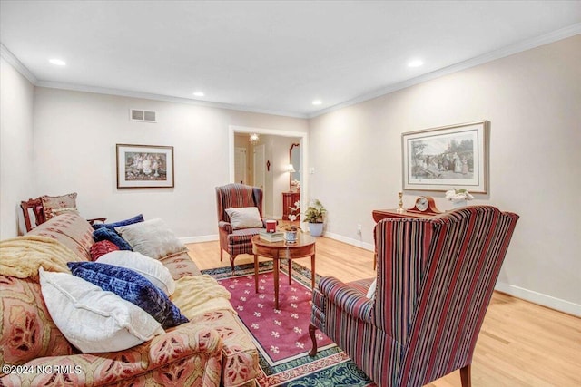 living room with light wood-type flooring and crown molding