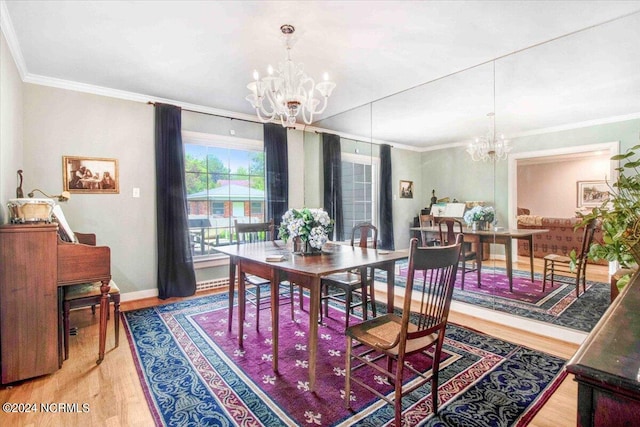 dining space with ornamental molding, a chandelier, and hardwood / wood-style flooring