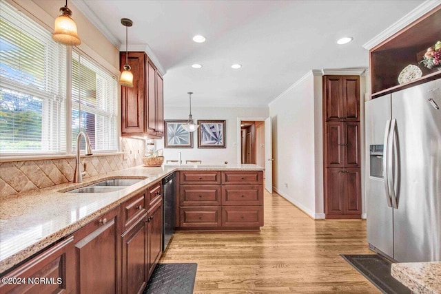 kitchen featuring sink, hanging light fixtures, light hardwood / wood-style flooring, stainless steel appliances, and decorative backsplash