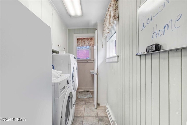 washroom featuring wood walls and washer and clothes dryer