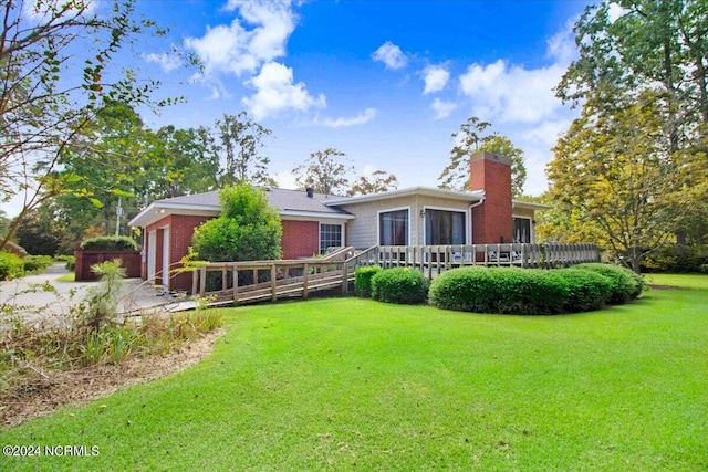 1803 Sedgefield Dr, Kinston, NC 28504 - back of property with a wooden deck, a lawn, brick siding, a garage, and a chimney