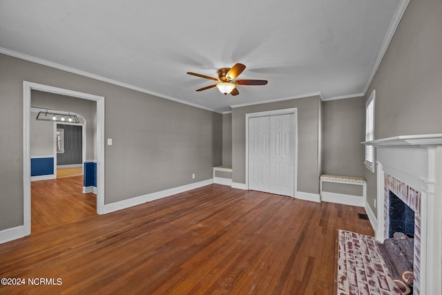 unfurnished living room featuring hardwood / wood-style floors, a fireplace, ornamental molding, and ceiling fan