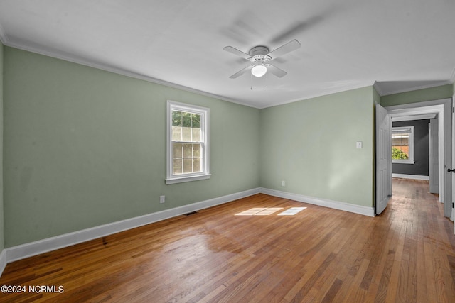 empty room featuring hardwood / wood-style floors, ornamental molding, and ceiling fan