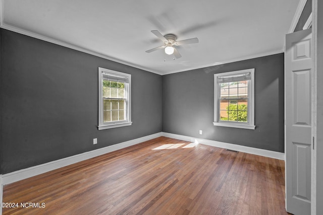 unfurnished room featuring crown molding, a healthy amount of sunlight, and hardwood / wood-style floors