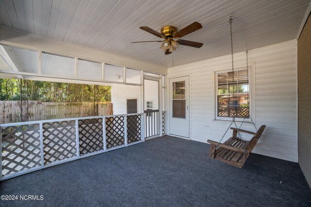 unfurnished sunroom featuring ceiling fan