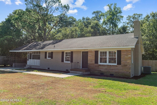 ranch-style home featuring central AC unit and a front yard