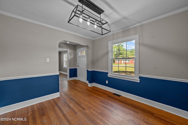 empty room featuring hardwood / wood-style floors and crown molding