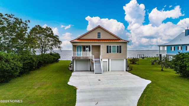 77 Indian Trl, Arapahoe, NC 28510 - coastal inspired home featuring a water view, concrete driveway, a front lawn, a garage, and metal roof