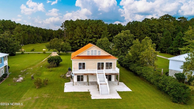77 Indian Trl, Arapahoe, NC 28510 - back of house with a patio, stairway, a view of trees, metal roof, and a yard