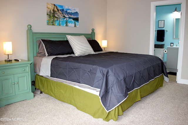 bedroom featuring ensuite bath and light carpet