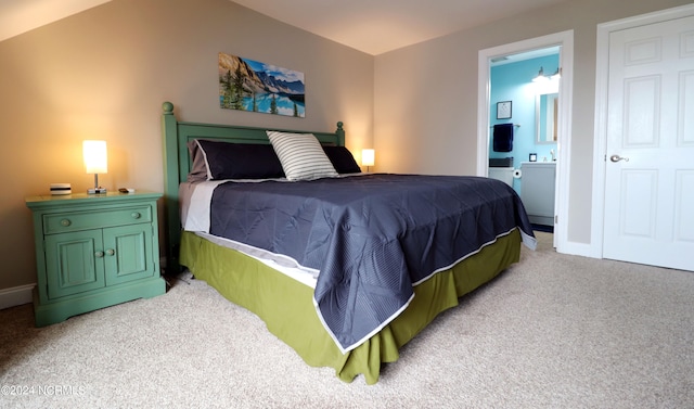 carpeted bedroom with vaulted ceiling and ensuite bathroom