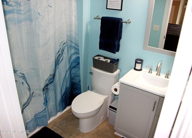 bathroom featuring a shower with shower curtain, vanity, toilet, and tile patterned floors