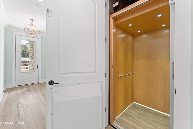 interior space featuring hardwood / wood-style floors, elevator, and a notable chandelier