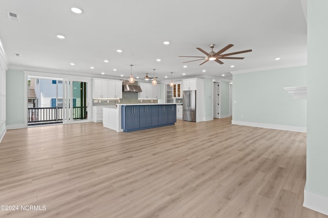 unfurnished living room with light wood-type flooring, ceiling fan, and ornamental molding