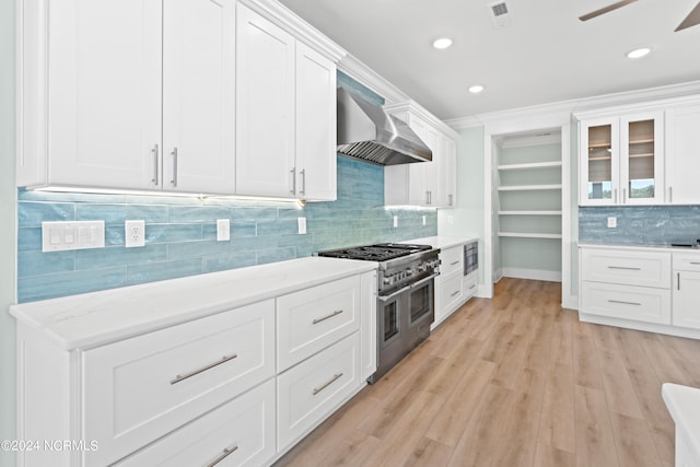 kitchen with white cabinets, double oven range, and wall chimney range hood