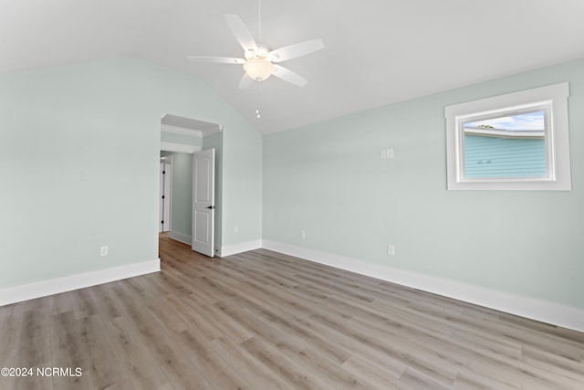 empty room with ceiling fan, light wood-type flooring, and vaulted ceiling