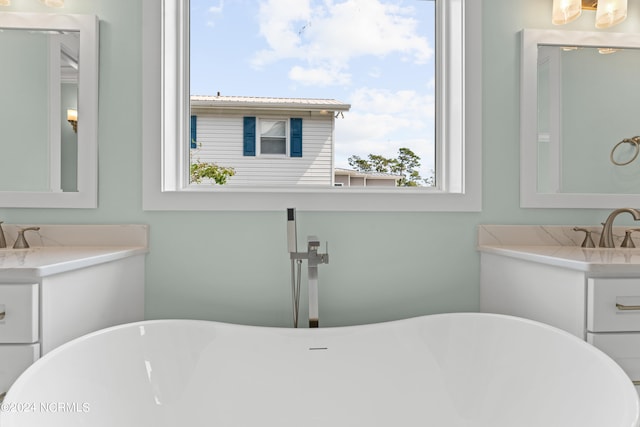 bathroom with vanity and a bath