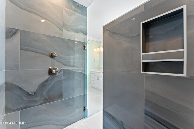 bathroom with tiled shower and vanity