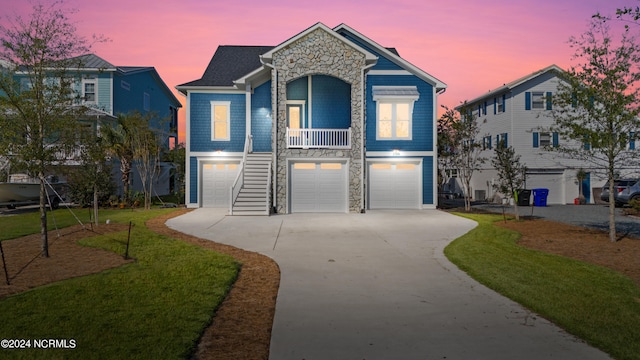 view of front facade featuring a lawn, a garage, and covered porch