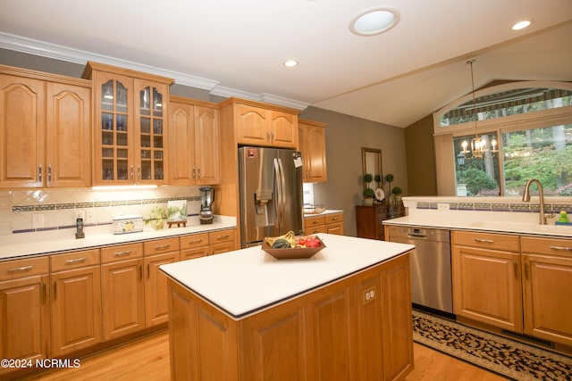 kitchen featuring appliances with stainless steel finishes, glass insert cabinets, light countertops, and a sink