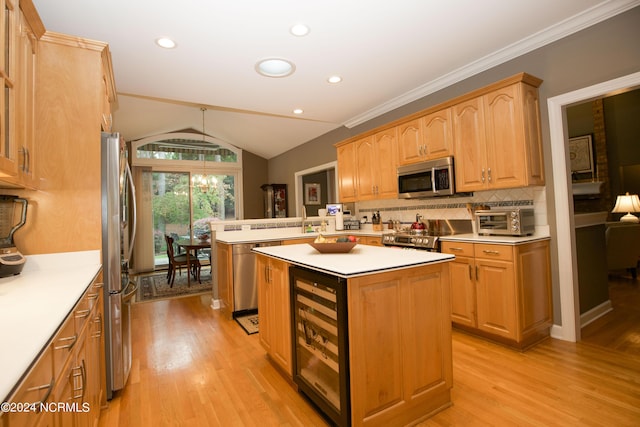 kitchen featuring wine cooler, stainless steel appliances, lofted ceiling, light countertops, and a kitchen island