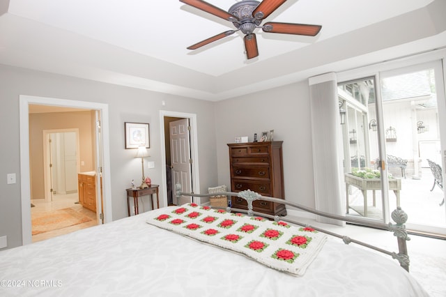 bedroom with access to outside, a tray ceiling, and a ceiling fan