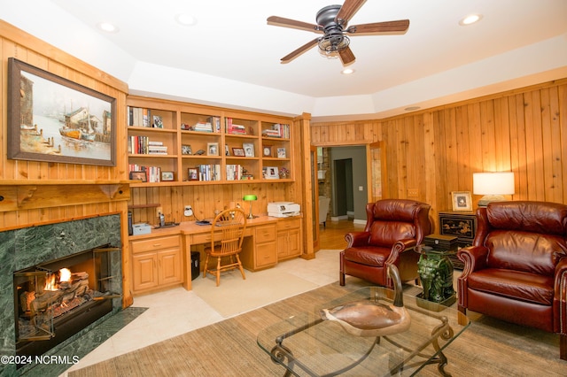 office featuring wood walls, light tile patterned floors, a ceiling fan, and built in desk