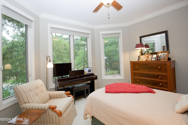 carpeted bedroom with ornamental molding and ceiling fan