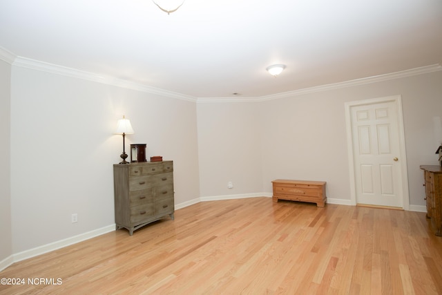 interior space with light wood-style floors, crown molding, and baseboards