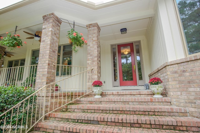 property entrance with brick siding and a ceiling fan