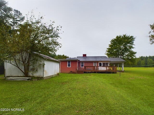 back of property with a yard and a wooden deck