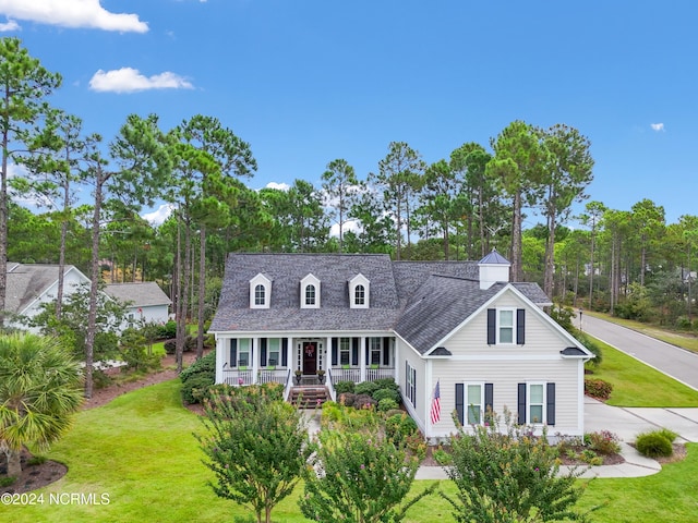 cape cod home with covered porch and a front yard