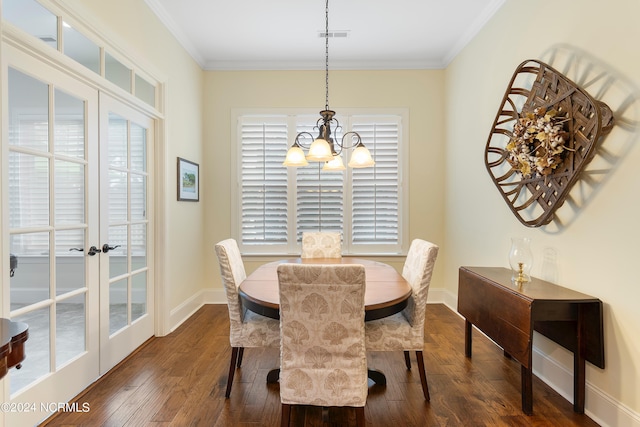 dining space featuring french doors, dark hardwood / wood-style floors, ornamental molding, and a notable chandelier