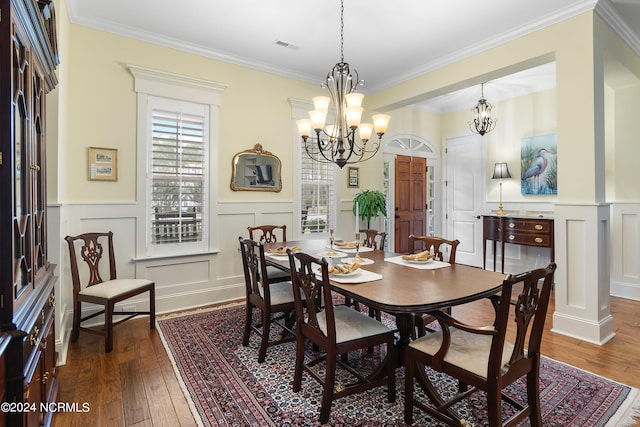 dining area featuring crown molding, dark hardwood / wood-style floors, and a notable chandelier