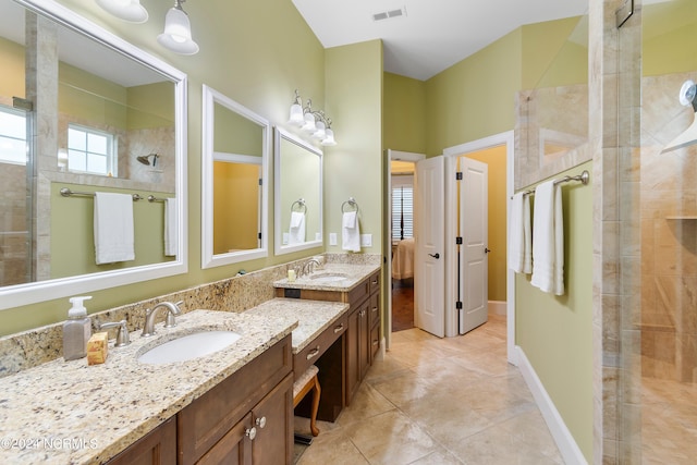 bathroom with tile patterned floors, plenty of natural light, a shower with shower door, and vanity