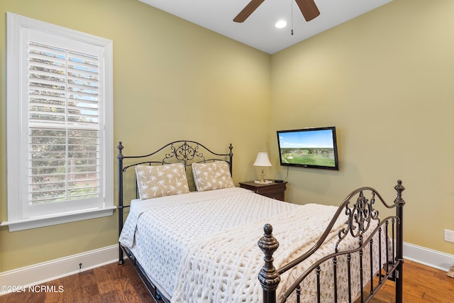 bedroom featuring multiple windows, dark hardwood / wood-style floors, and ceiling fan