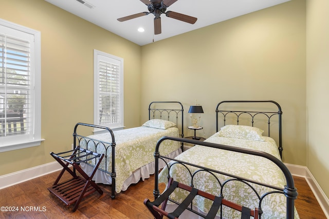 bedroom with ceiling fan, dark wood-type flooring, and multiple windows