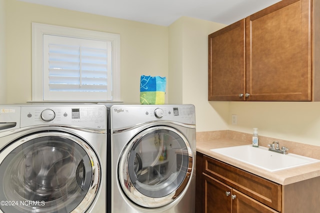 laundry room featuring cabinets, washing machine and dryer, and sink