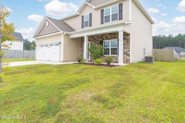 view of front of house featuring cooling unit, a front lawn, covered porch, and a garage