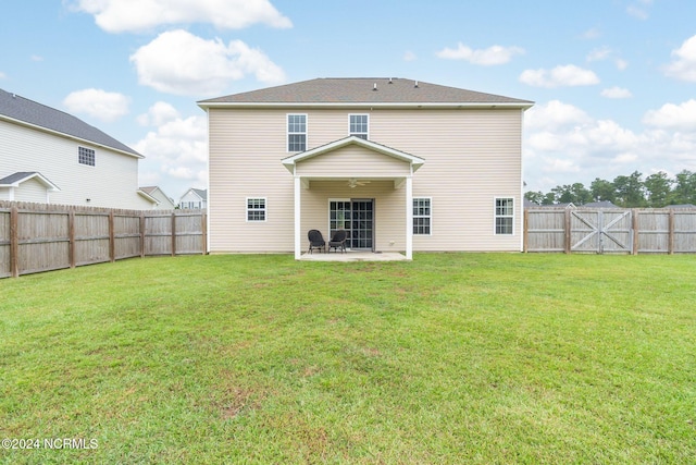 back of property with a lawn and a patio area