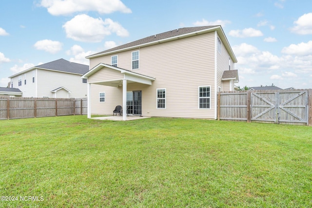 rear view of property with a patio and a lawn