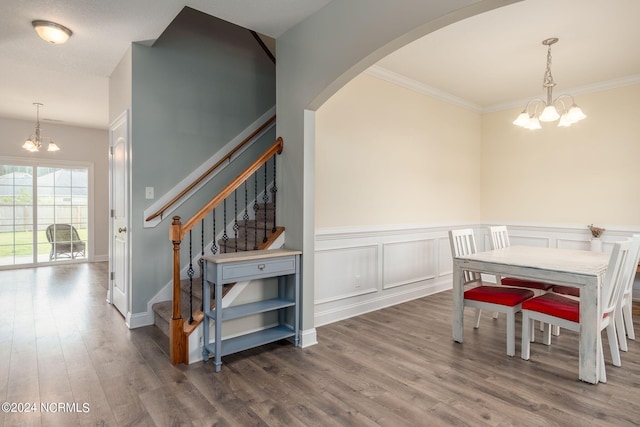 dining area with crown molding, an inviting chandelier, and dark wood-type flooring