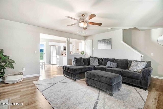 living room featuring light hardwood / wood-style flooring and ceiling fan