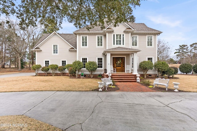 view of front of home with a shingled roof and a front yard