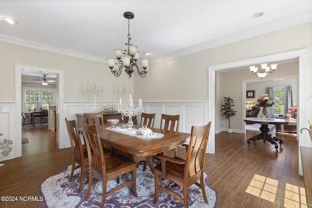 dining area with crown molding, a decorative wall, a chandelier, wood finished floors, and wainscoting