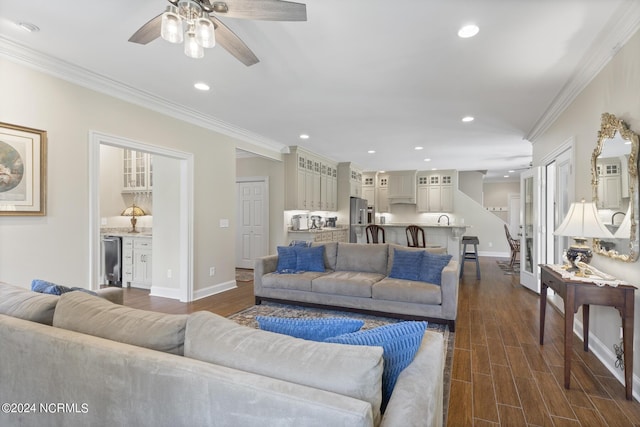 living area with ornamental molding, baseboards, and a ceiling fan