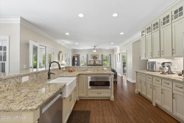 kitchen with recessed lighting, glass insert cabinets, dark wood finished floors, stainless steel dishwasher, and a sink